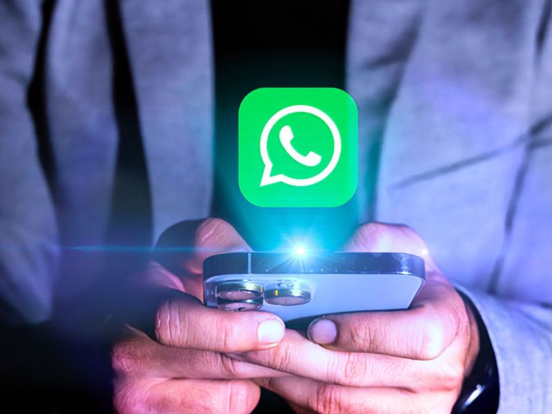 WhatsApp-Symbol schwebt über einem leuchtenden Smartphone