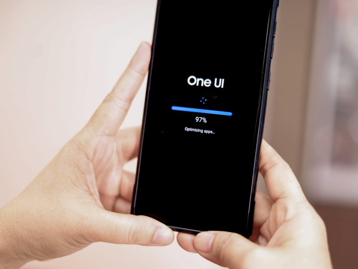 Person hält ein Handy in der Hand, auf dem ein Software-Update durchgeführt wird.