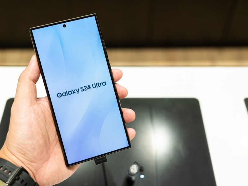 Person hält ein Handy in der Hand, auf dessen Display steht Galaxy S24 Ultra.