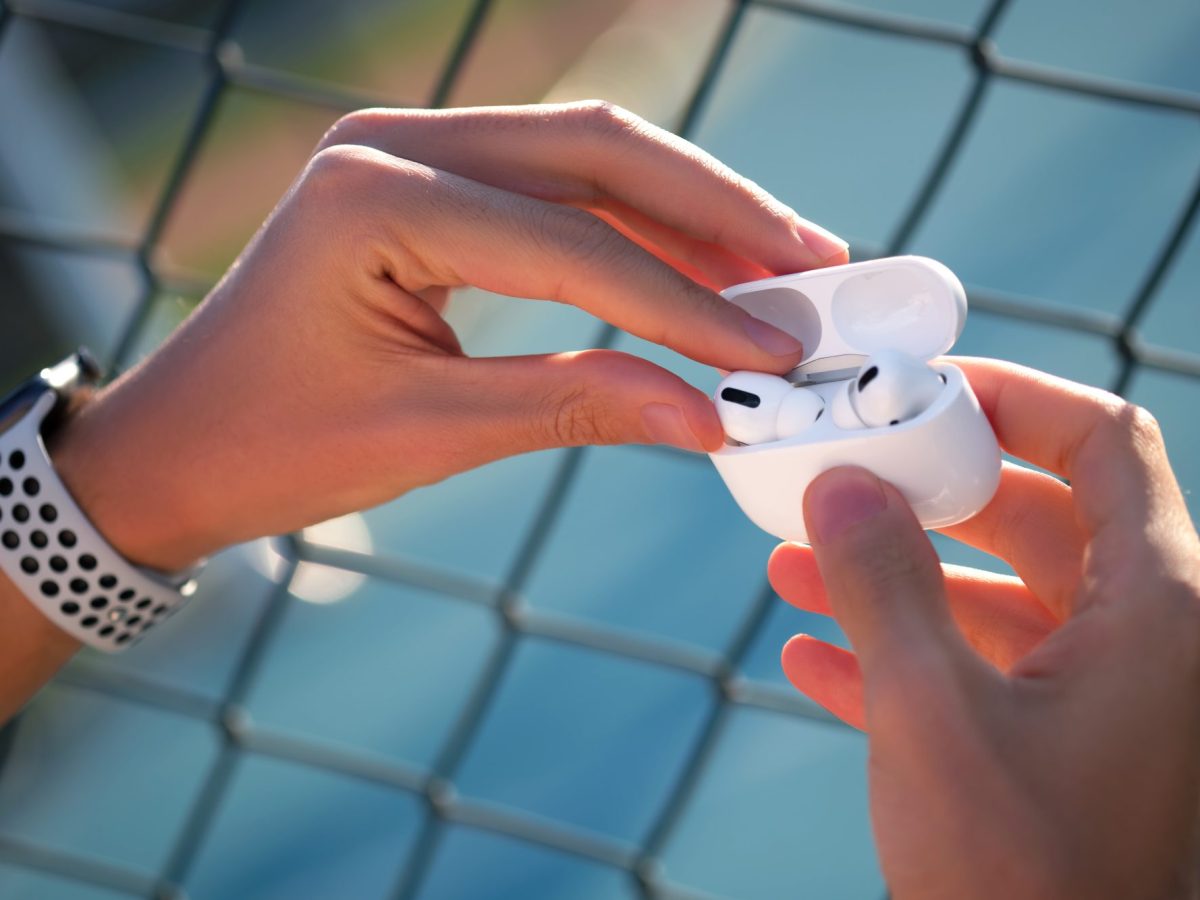 Person hält AirPods in der Hand.