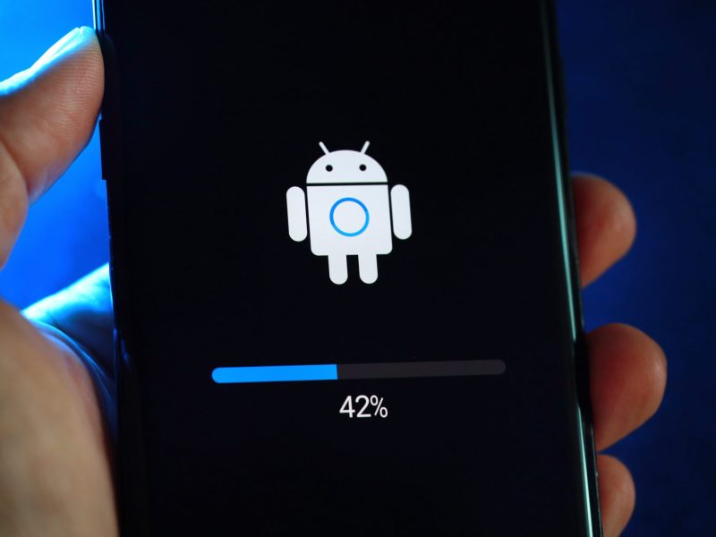 Person hält Handy in der Hand, auf dem ein neues Android-Update geladen wird.
