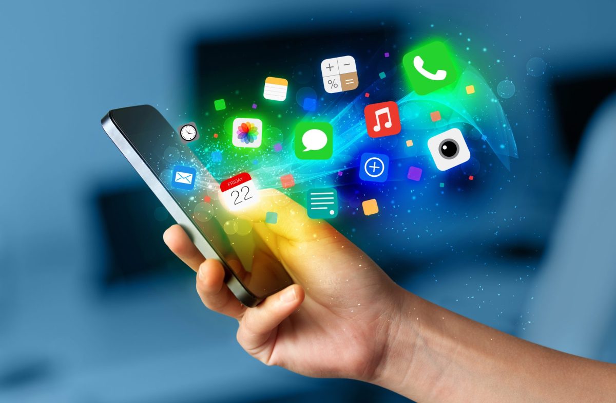 Person hält ein Handy in der Hand. Davor werden mehrere App-Symbole angezeigt.