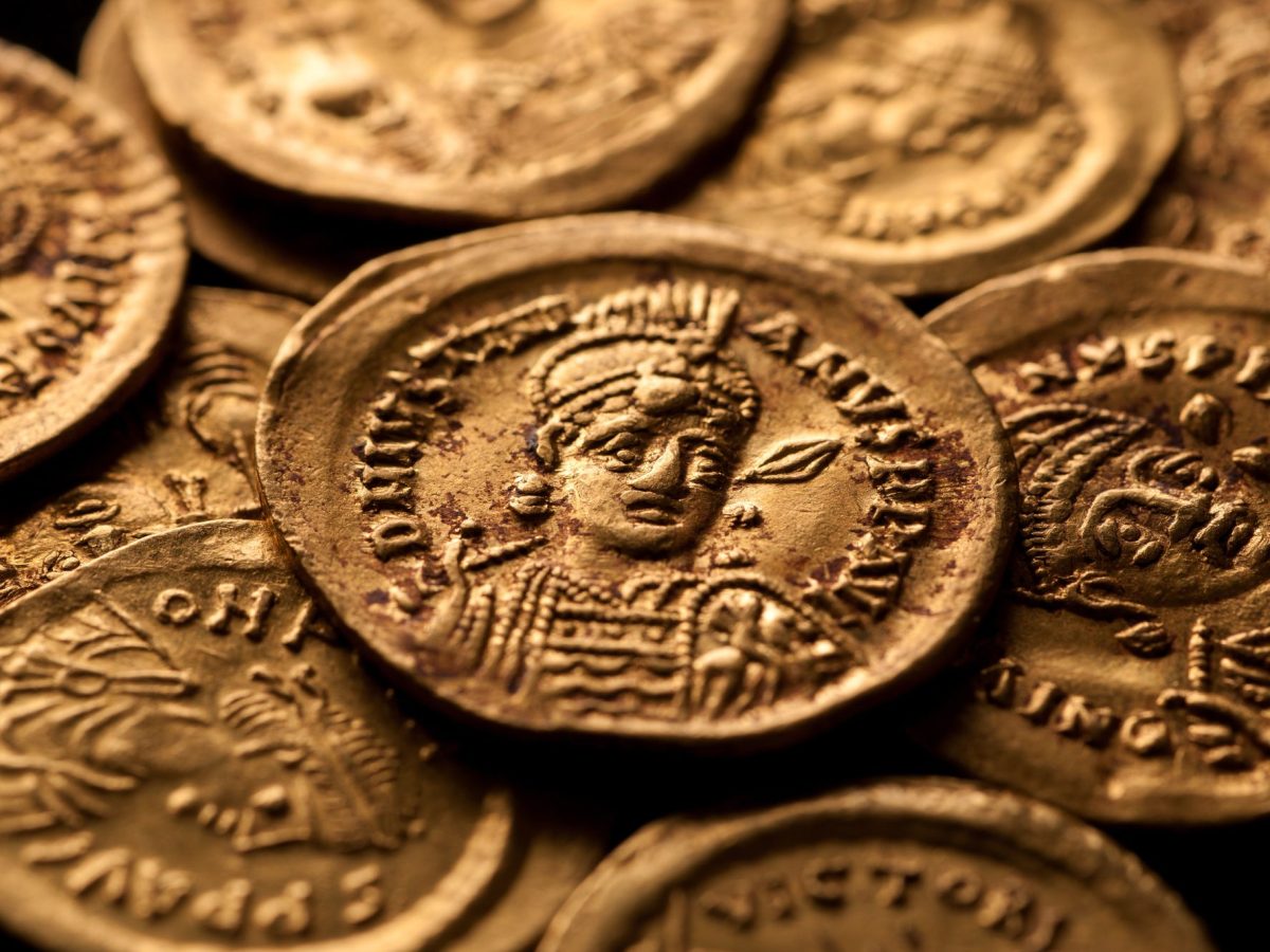 Goldmünzen als archäologischer Fund auf einem Haufen.
