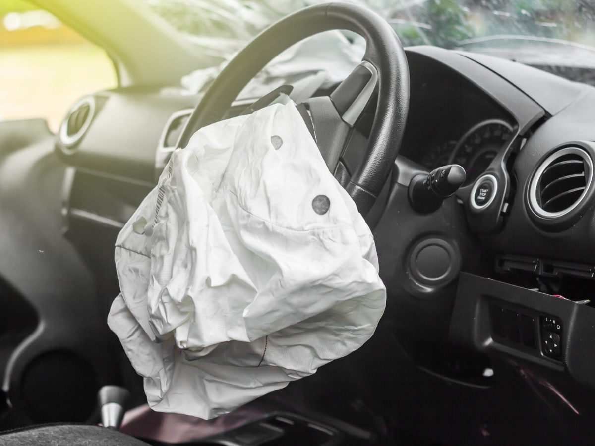Ausgelöster Airbag am Lenkrad eines Autos.