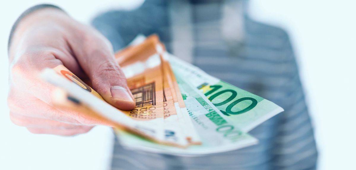 Mann hält Bargeld in der Hand