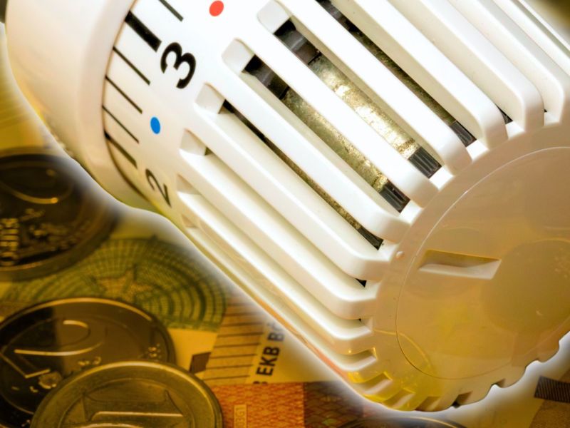 Heizungsregler auf einem Haufen aus Geld