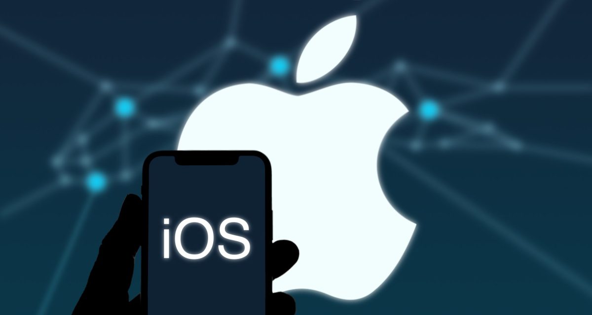 iOS-Logo auf einem Handy-Bildschirm, im Hintergrund ist das Apple-Logo zu sehen.
