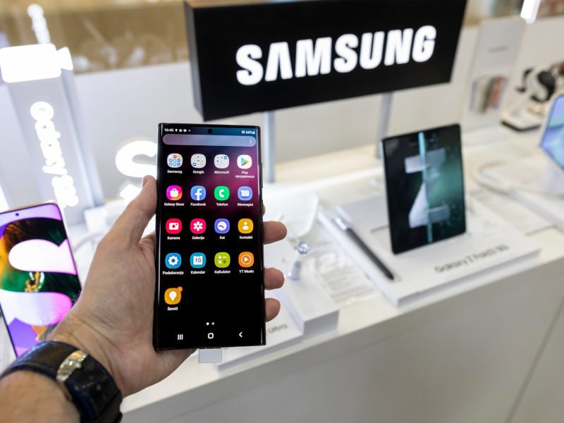 Person hält ein Samsung-Handy in der Hand, auf dem mehrere Apps angezeigt werden.