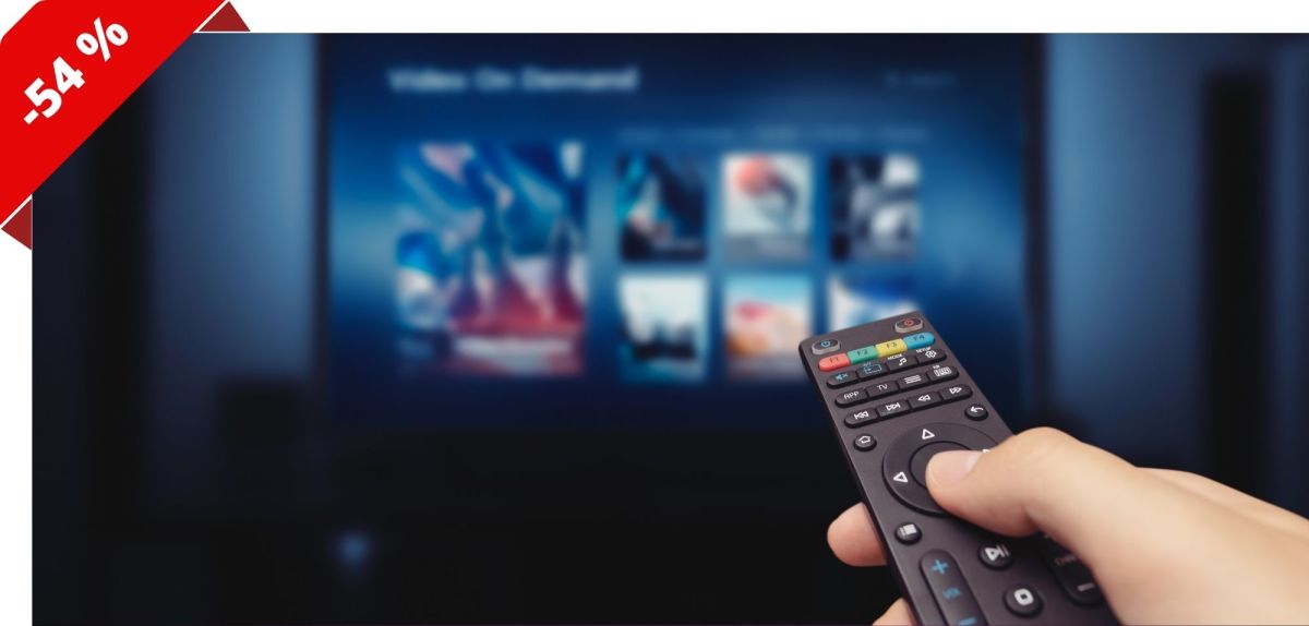 Person hält Fernbedienung in Richtung eines Fernsehers.