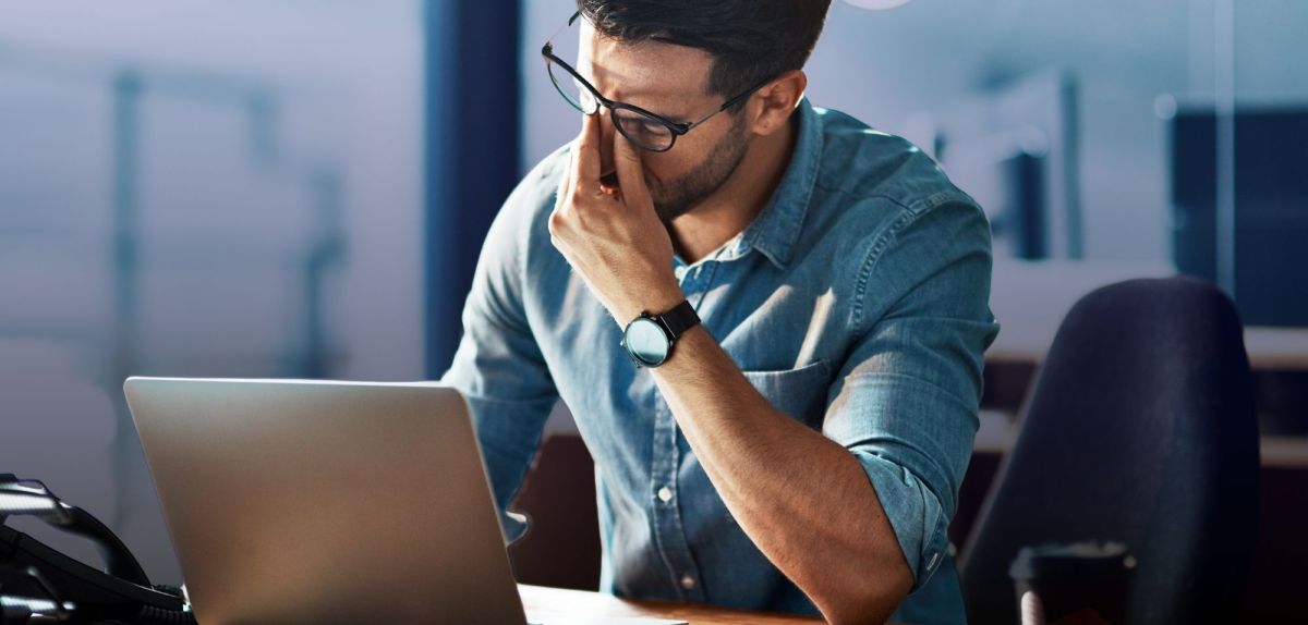 Man sitzt verzweifelt vor seinem Laptop