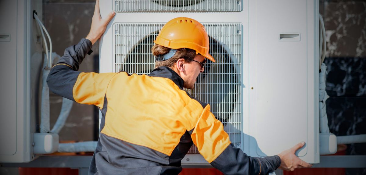 Handwerker arbeitet an einer Wärmepumpe.