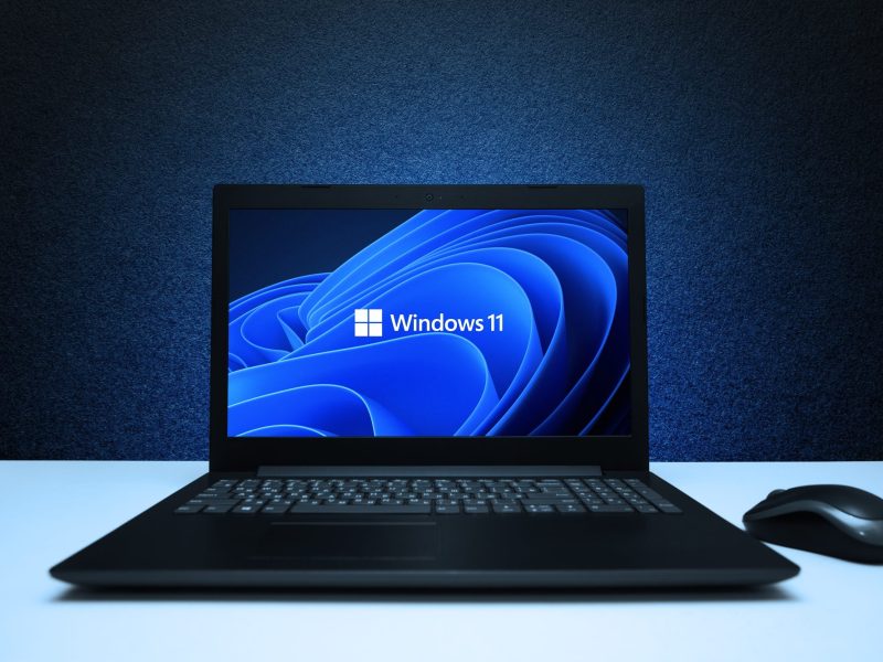 Windows 11-Logo wird auf einem Laptop angezeigt.