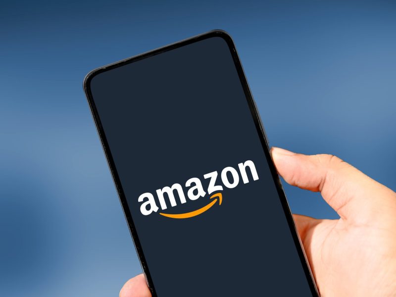 Amazon-Logo wird auf einem Handy-Display angezeigt.