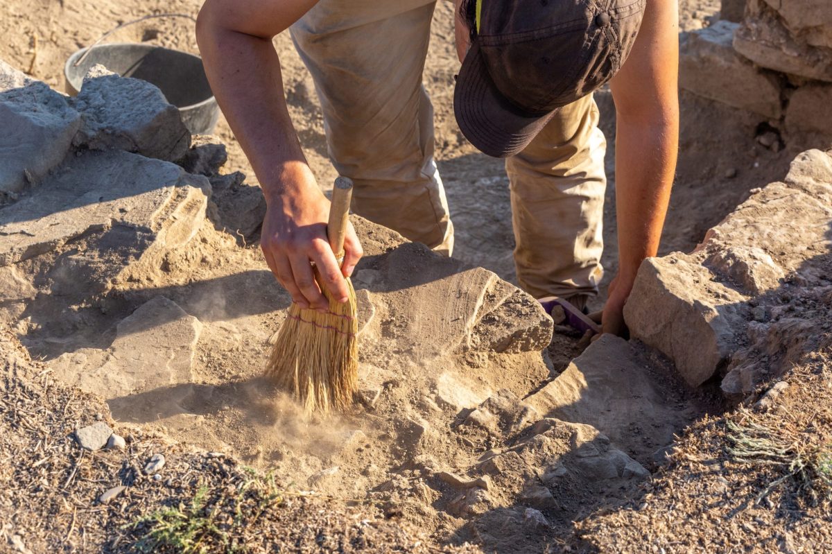 Person legt einen archäologischen Fund frei.