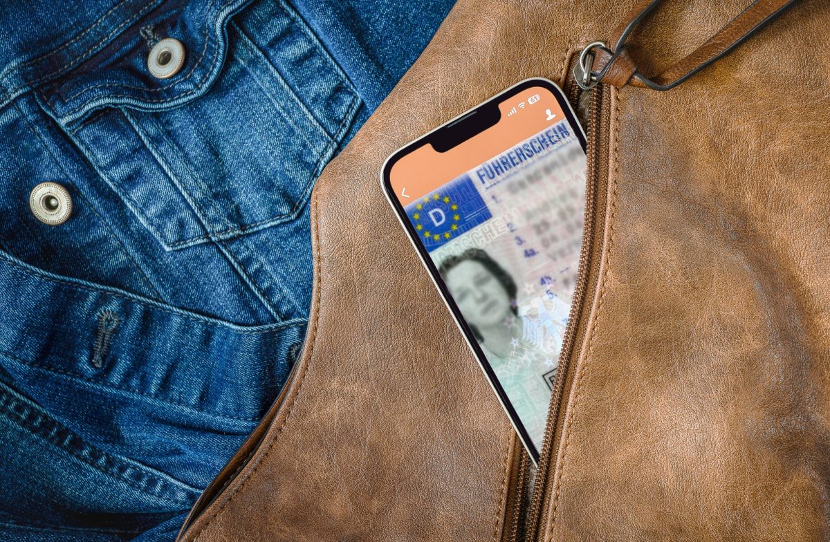 Führerschein auf einem Handy, das in einer Jackentasche steckt.