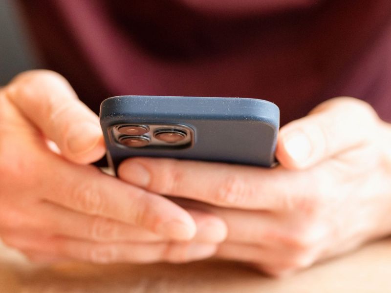 Mann hält iPhone in den Händen