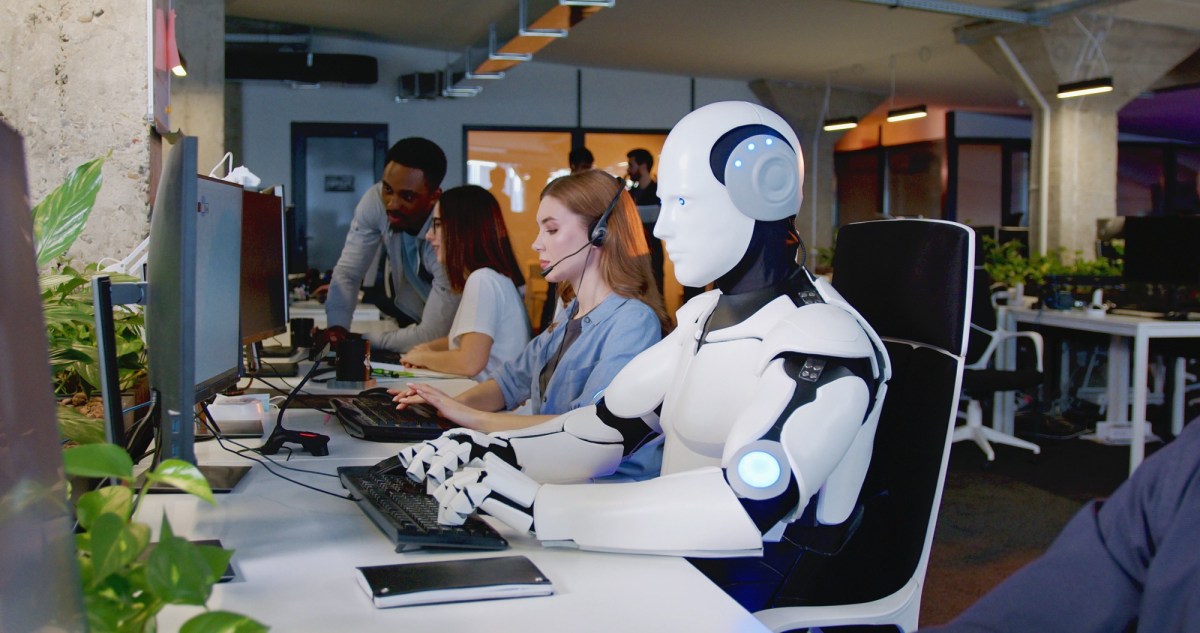 Roboter sitzt im BÃ¼ro mit Menschen am Tisch