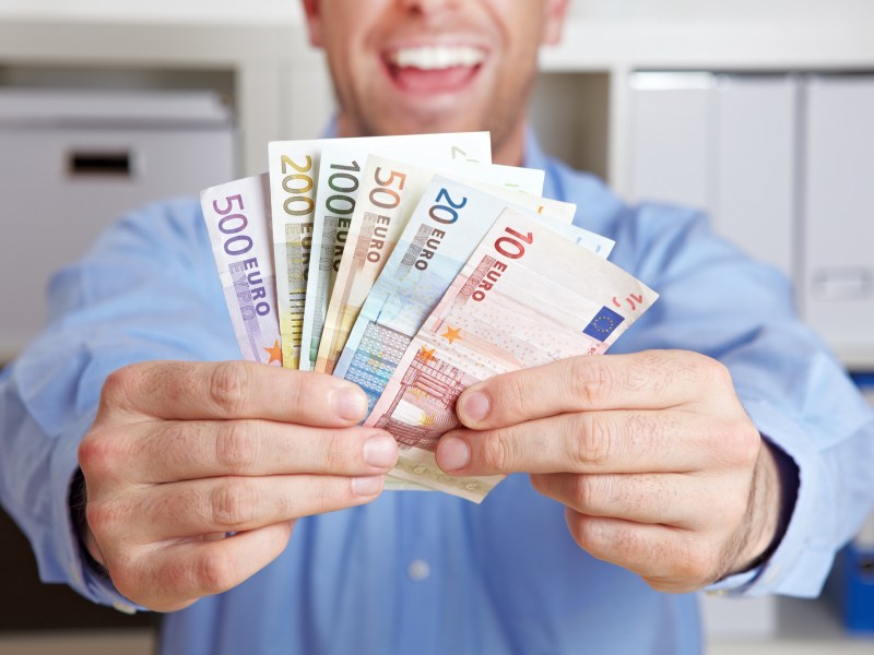 Mann hält Geldscheine in der Hand