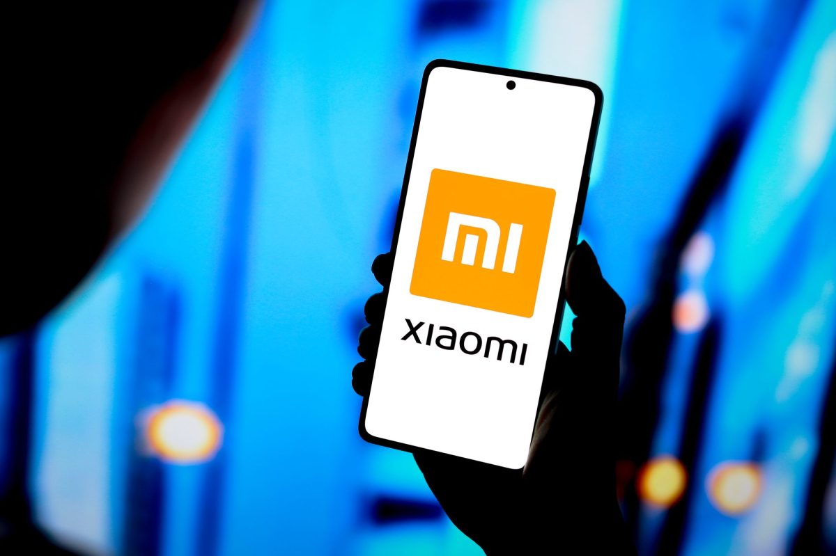 Person hält ein Smartphone in der Hand, auf dem Display ist das Xiaomi-Logo.