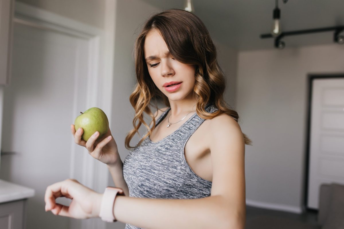 Frau guckt irritiert auf ihre Apple Watch.