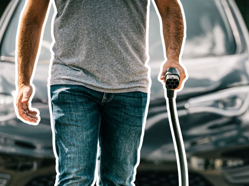Mann mit Ladekabel vor einem Elektroauto