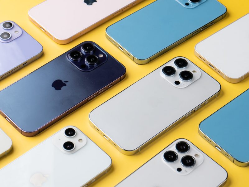 Verschiedene iPhone-Modelle auf gelben Untergrund.