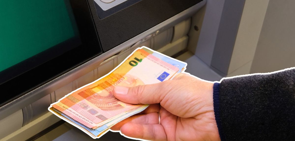 Person hebt an einem Automaten Geld ab.