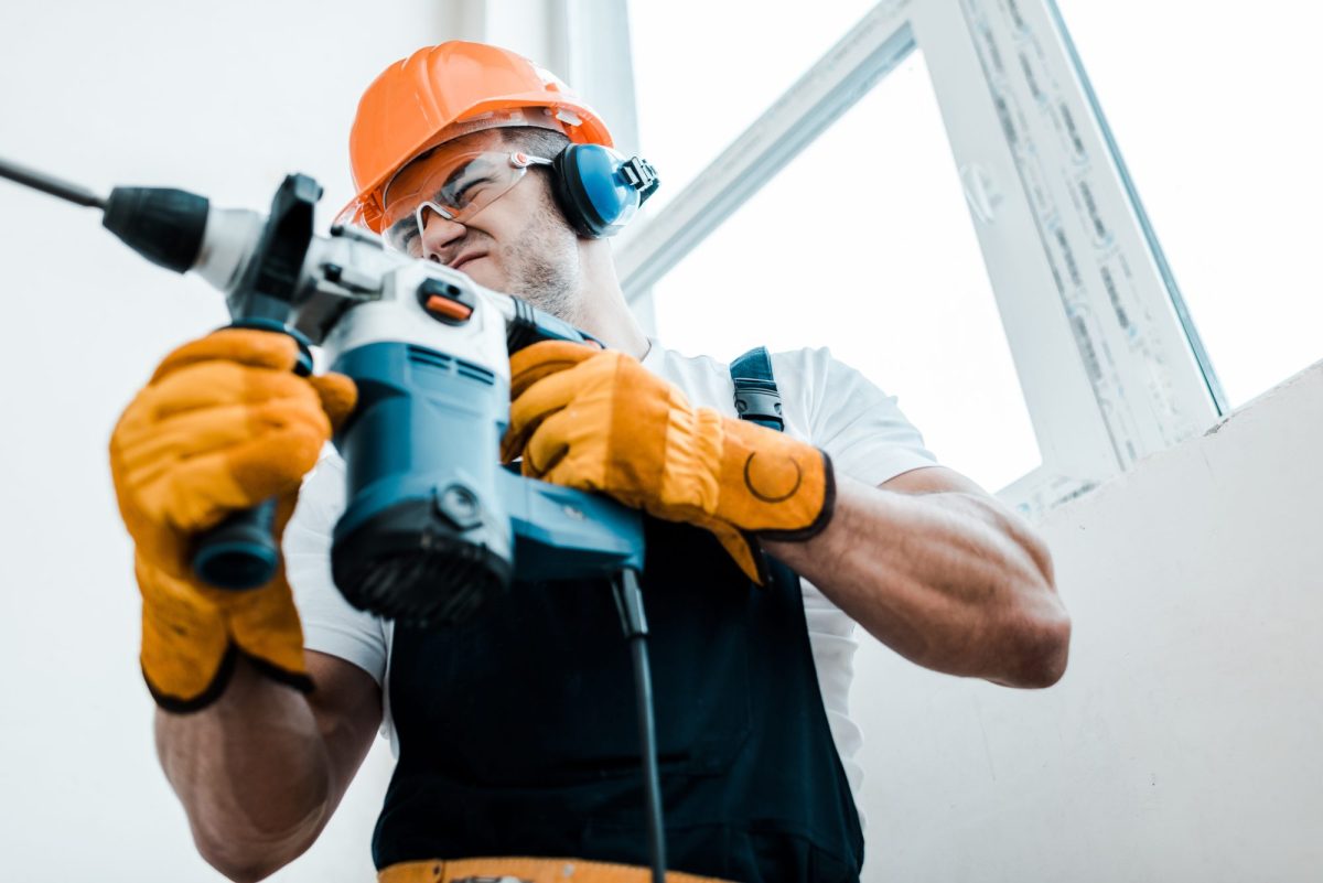 Mann benutzt einen Makita-Bohrhammer.