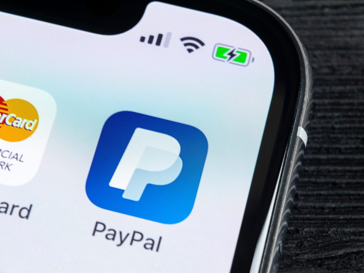 PayPal-App wird auf einem Handy-Display angezeigt.