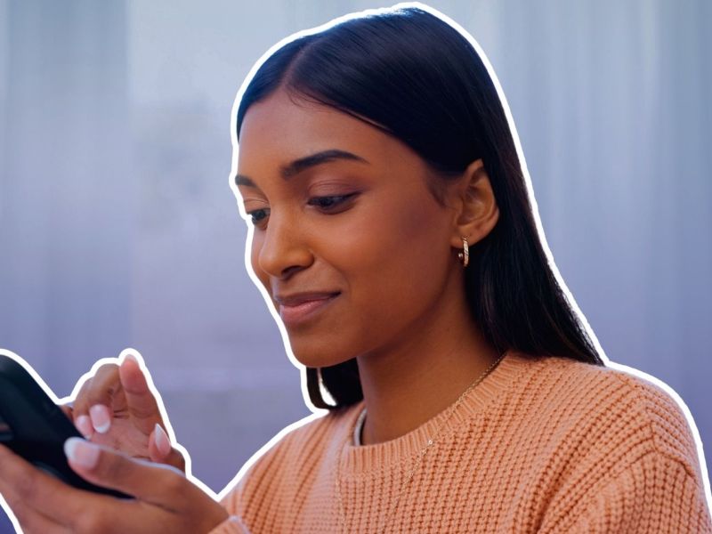 Frau blickt zufrieden auf ihr Smartphone