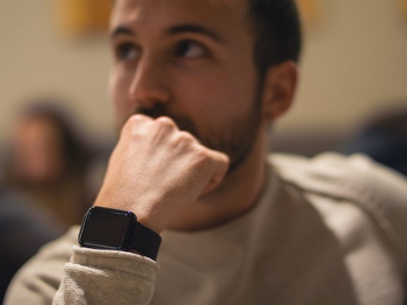 Person trägt eine schwarze Apple Watch am Handgelenk.