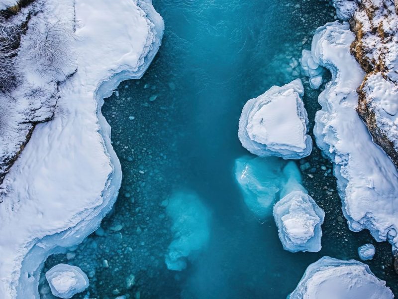 KI-generiertes Bild von Wasser und Schnee in einer Schlucht aus Gestein und Eisbergen.