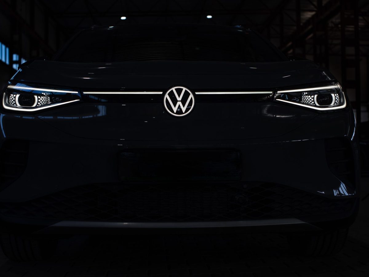 Elektroauto von VW im Dunkeln. Nur die Scheinwerfer und das Logo sind zu sehen.