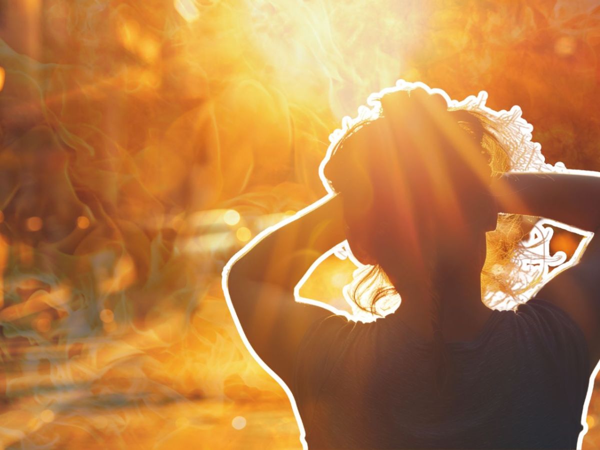 Frau hält sich, geblendet von der Sonne, die Hände über die Augen