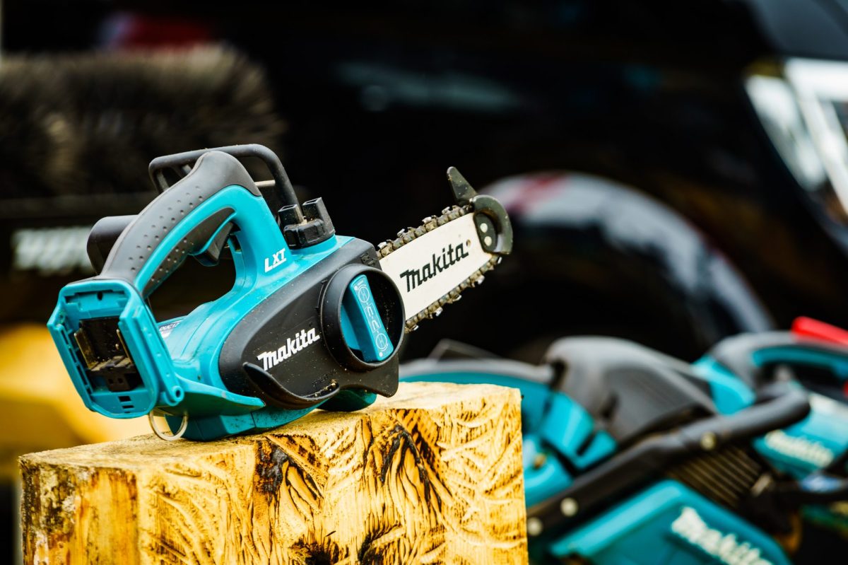 Makita-Akku-Kettensäge auf einem Holzblock.