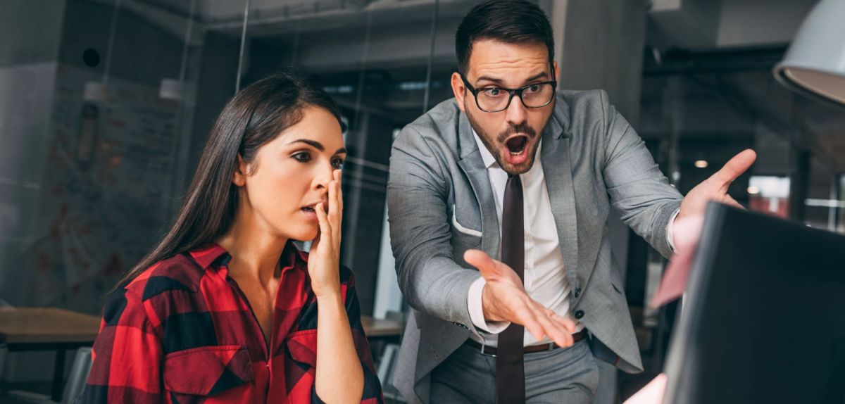 Frau und Mann schockiert vor Monitor