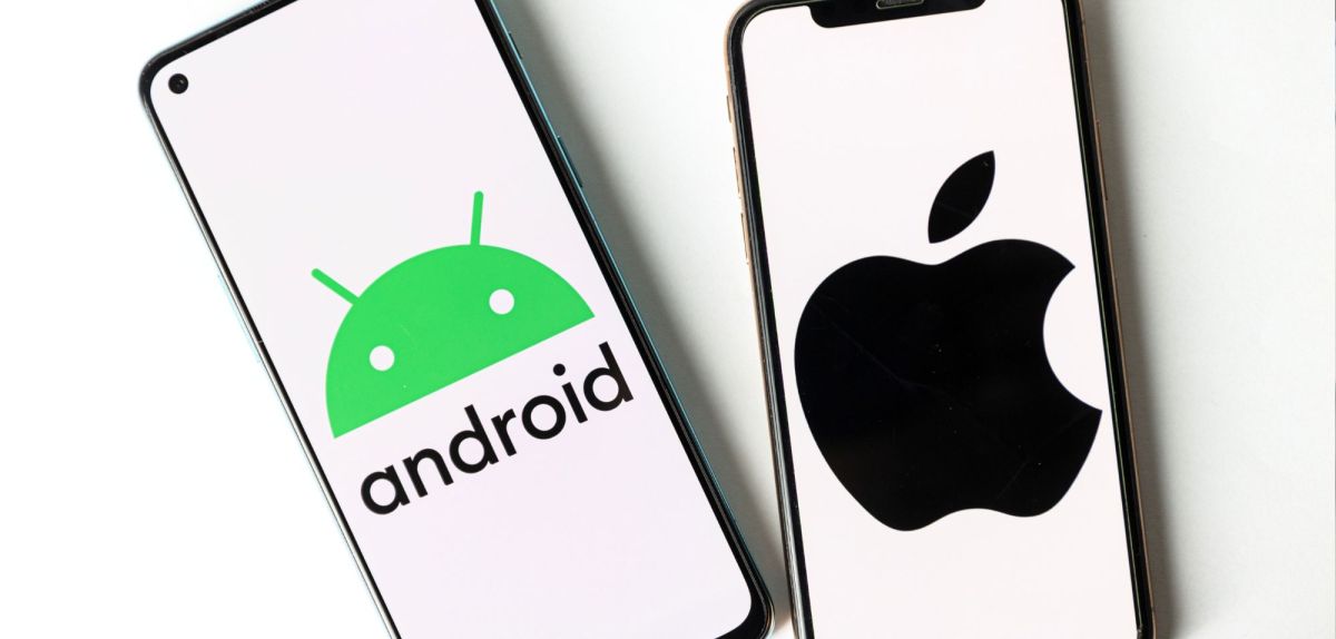 Zwei Handys nebeneinander. Auf dem einen ist das Android-Logo zu sehen, auf dem anderen das Apple-Logo.