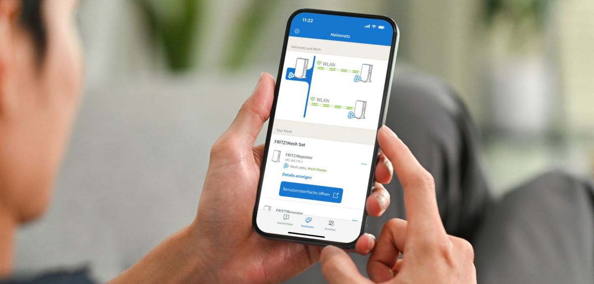 Mann hält Handy mit der FritzApp Smart Home darauf.