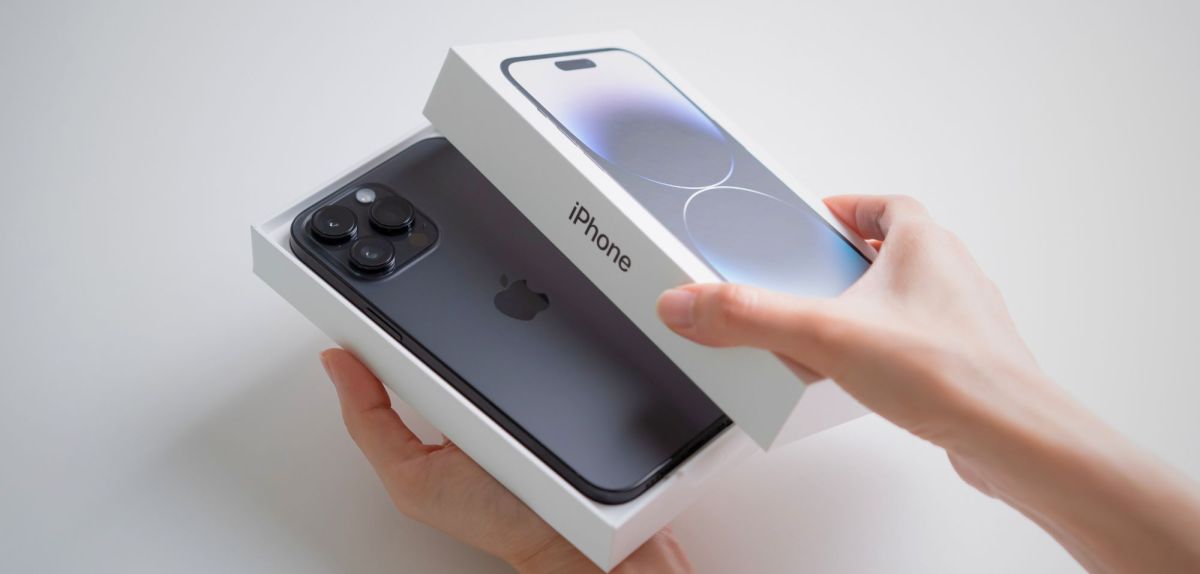 Person öffnet eine iPhone-Verpackung.