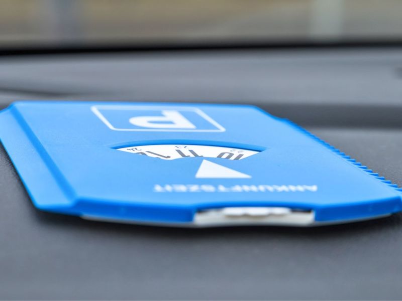 Blaue Parkscheibe liegt auf dem Armaturenbrett eines Autos