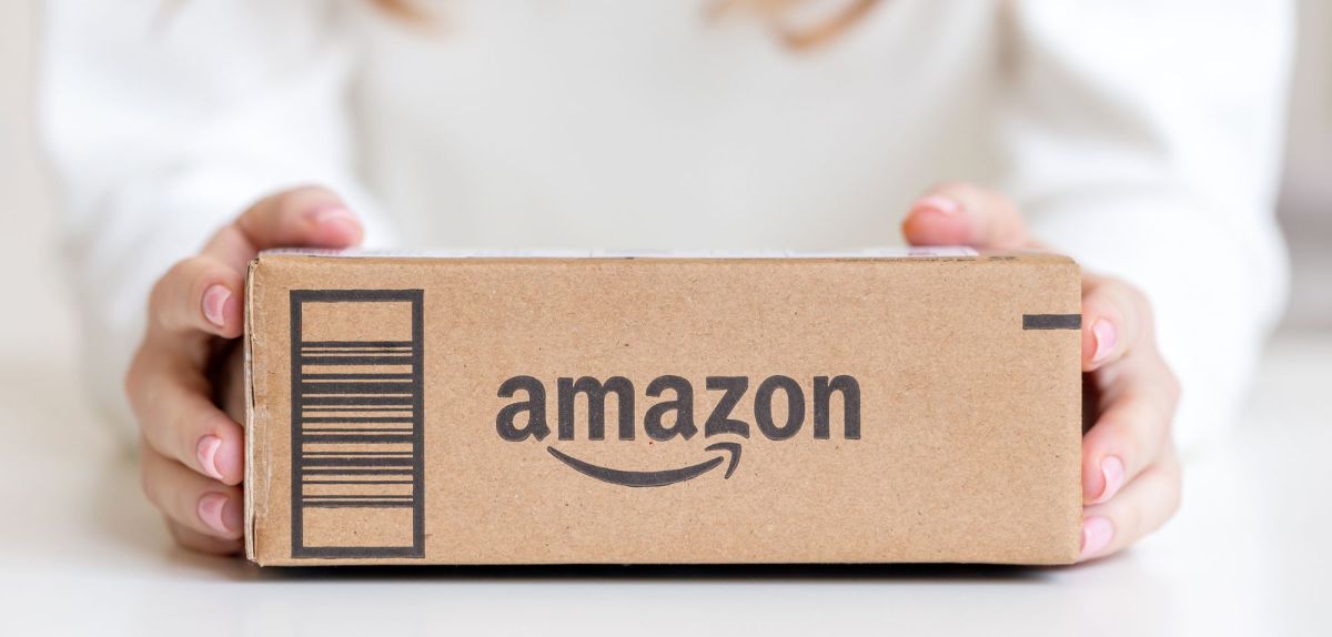 Frau hält ein Amazon-Paket in den Händen