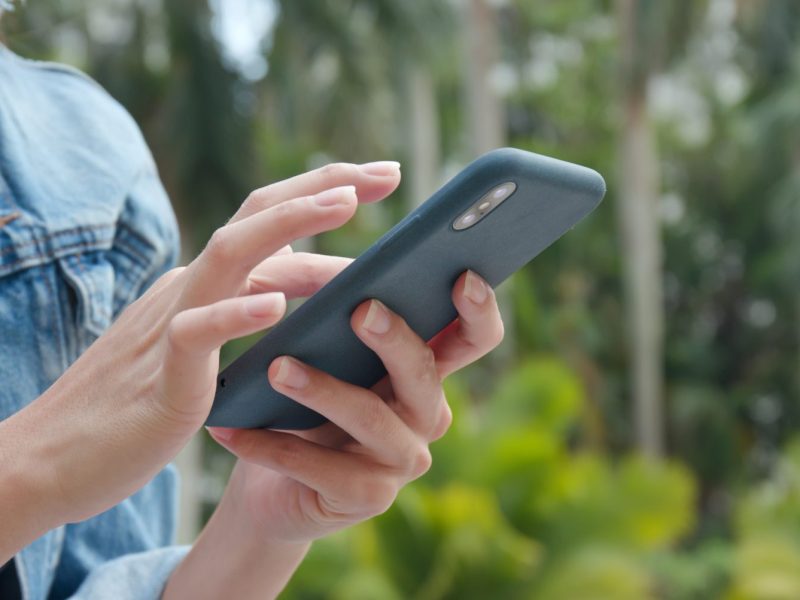 Frau mit Handy in der Natur