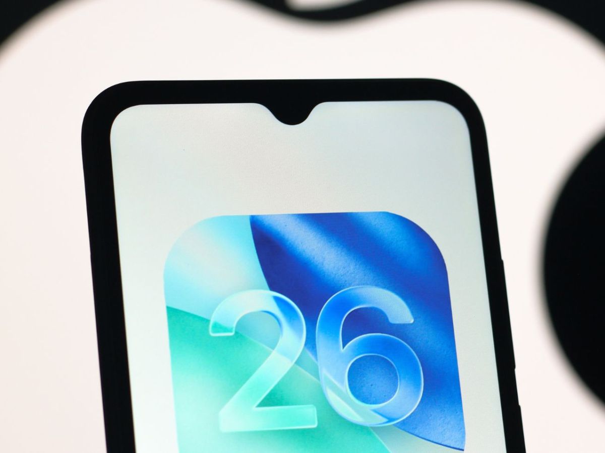 iOS 26-Logo auf einem Handy-Display. Im Hintergrund ist das Apple-Logo.
