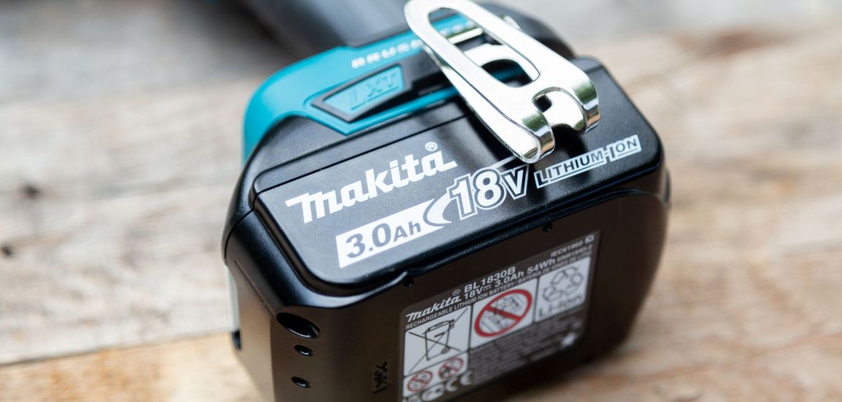 Makita-Akku an einem Schrauber auf einem Tisch.