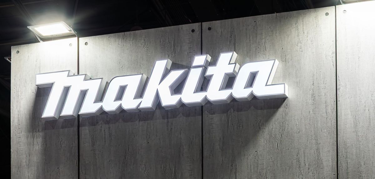 Makita-Logo an einer Wand mit Holzoptik.