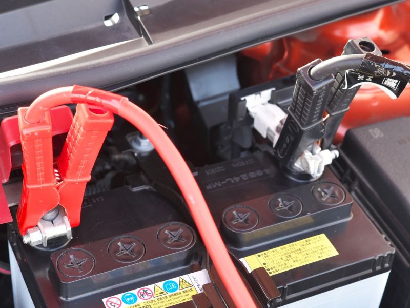Starthilfekabel an einer Autobatterie angeschlossen.