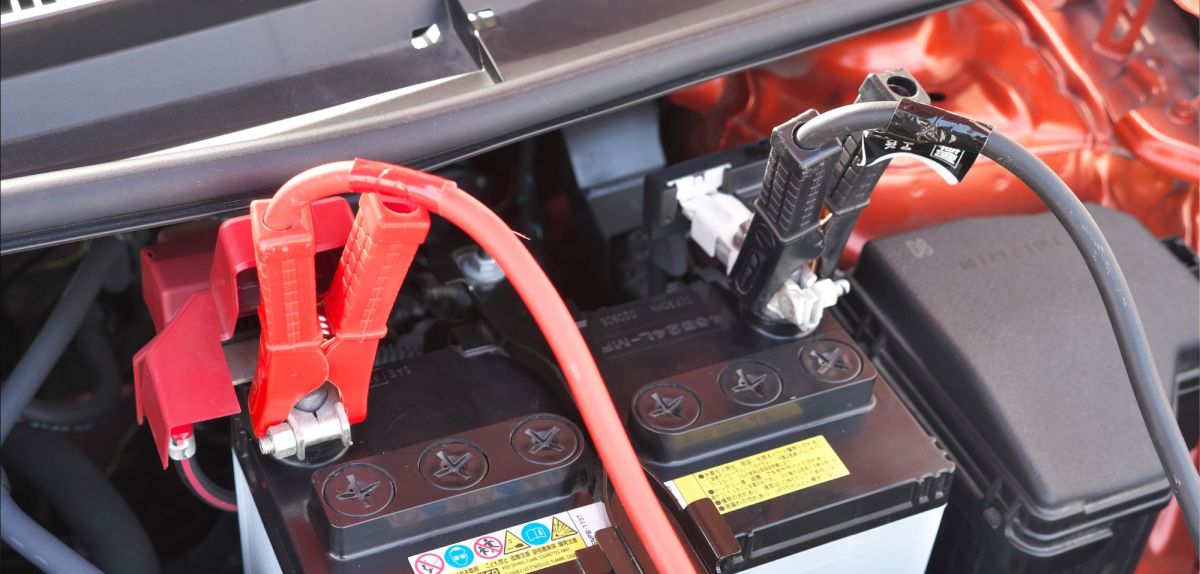 Starthilfekabel an einer Autobatterie angeschlossen.