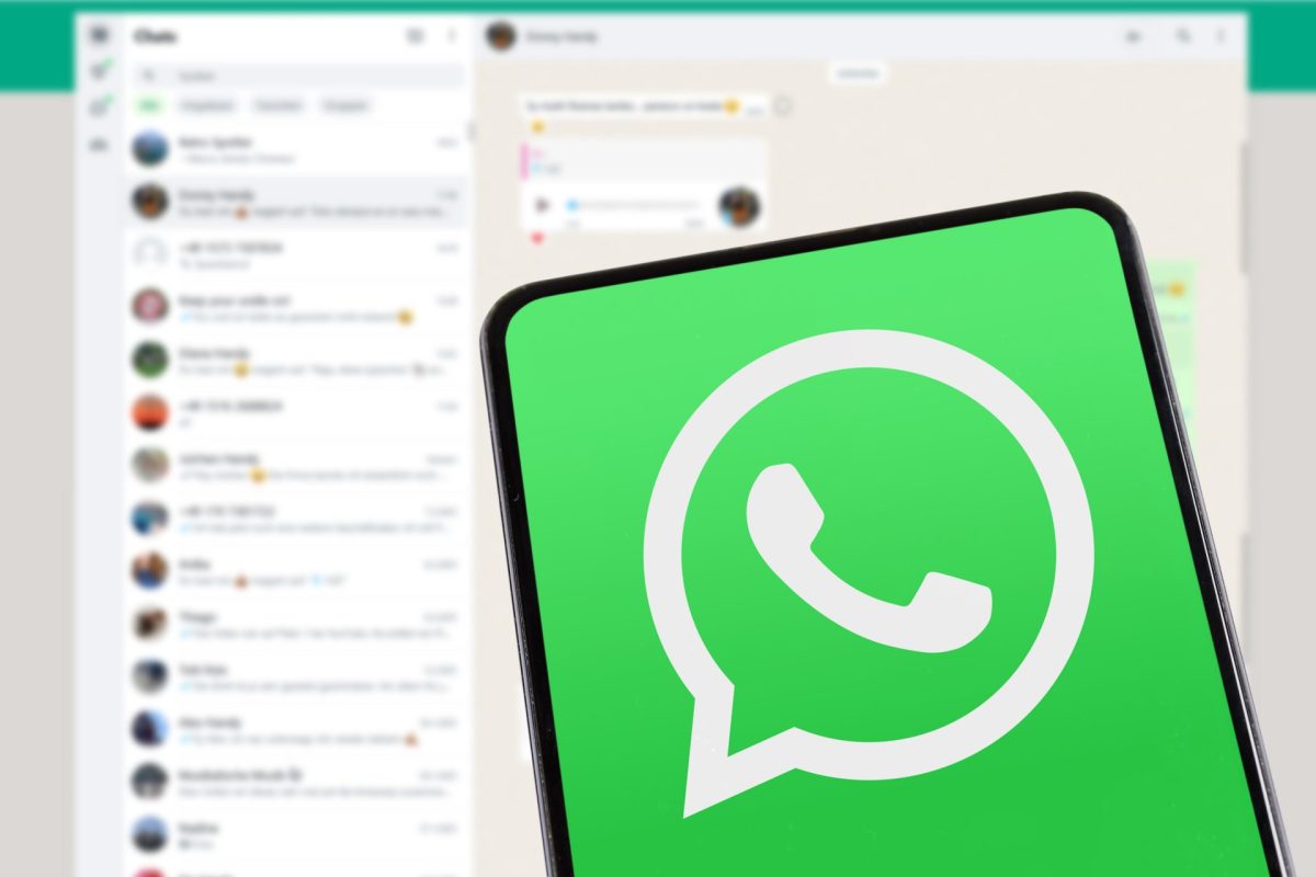 WhatsApp-Logo mit Chats im Hintergrund