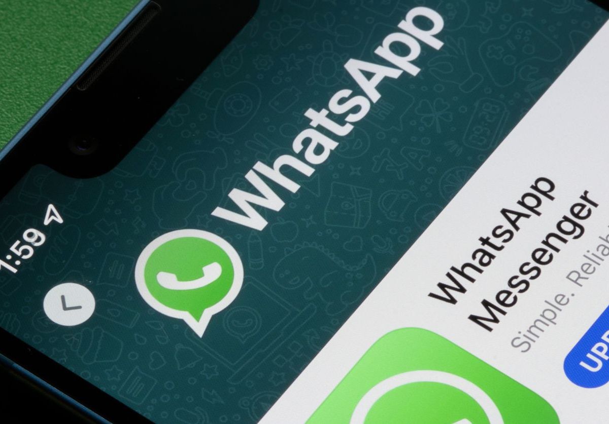 Smartphone-Bildschirm wird gezeigt. Man sieht das WhatsApp-Icon und ein Update-Button.