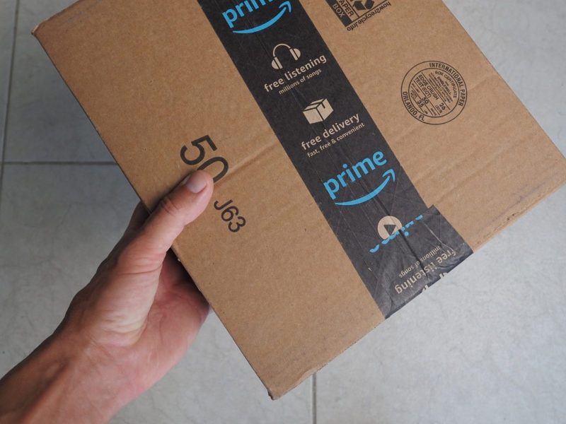 Hand hält ein Amazon Prime-Paket.
